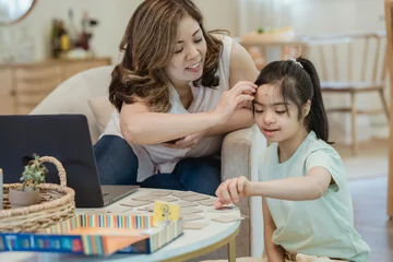 Young girl playing board game with mother