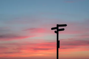 A crossroads sign at sunset